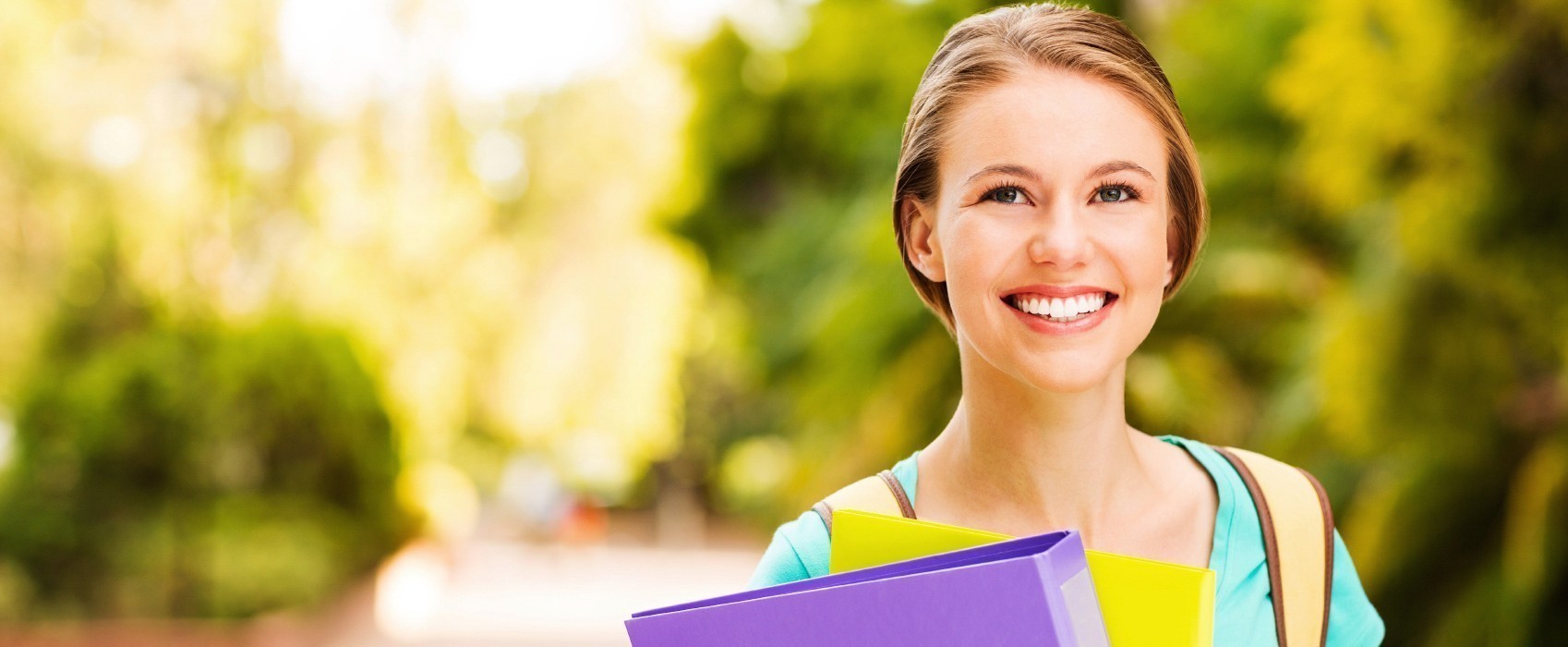 Student With Files Looking Away On University Campus